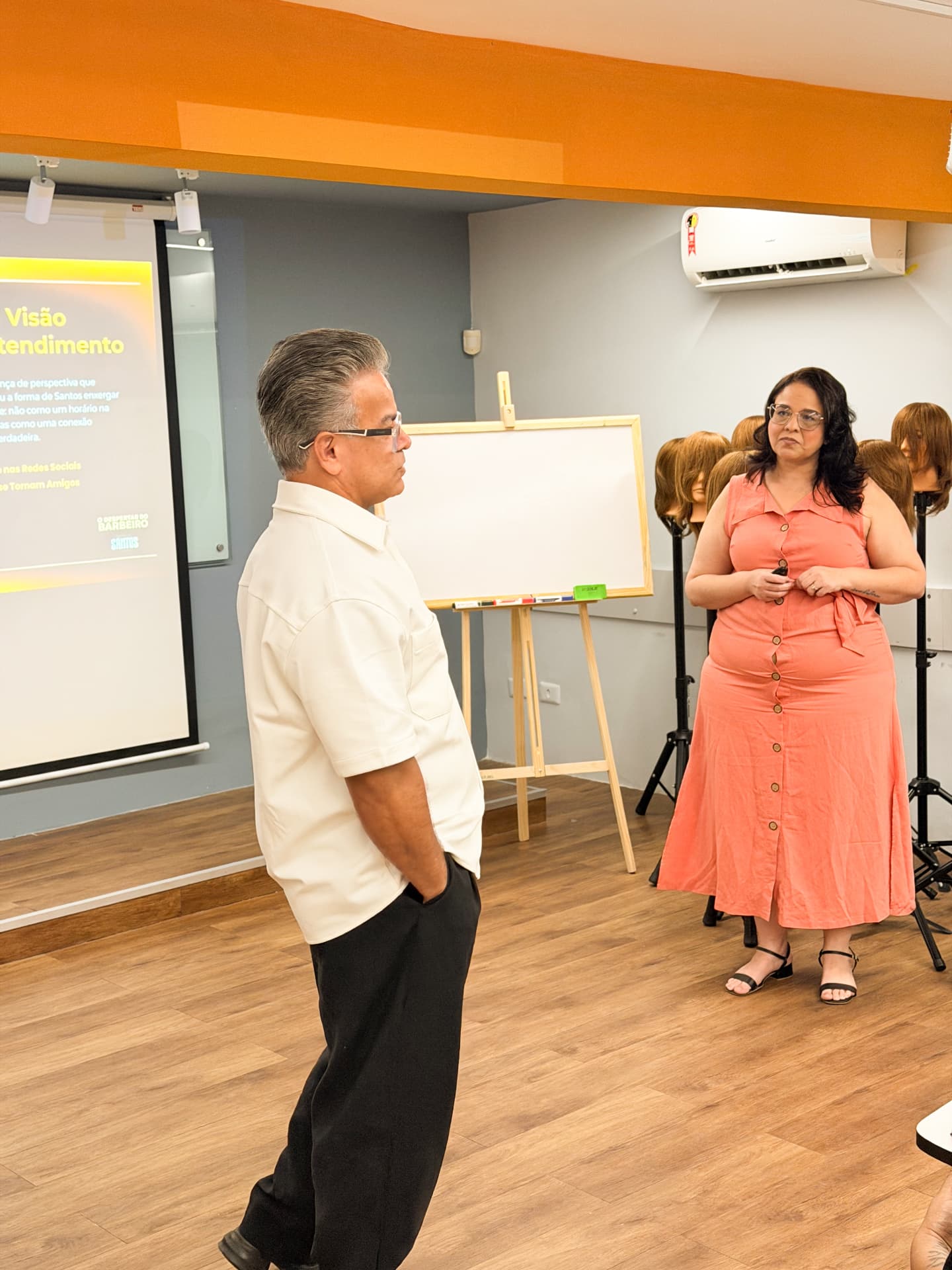 Santos conversando com uma participante em sala.
